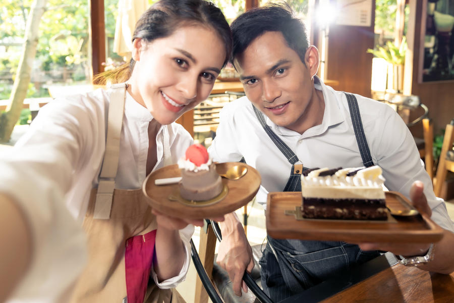 A couple showing off their desserts in a cafe
